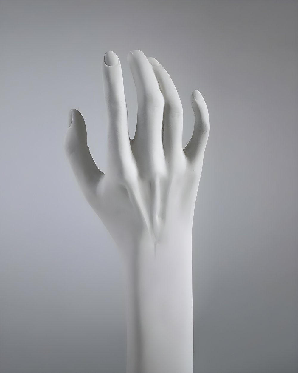 White sculpted hand against a grey background